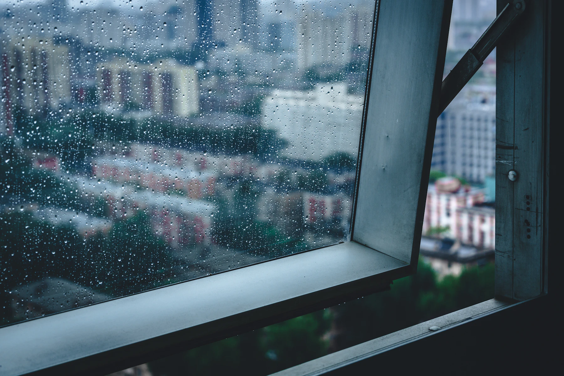 打開的窗框,玻璃上有雨滴